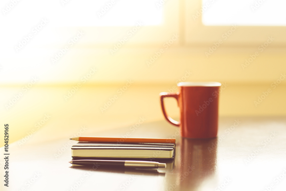Fototapeta premium Notepads and pens with cup of hot drink
