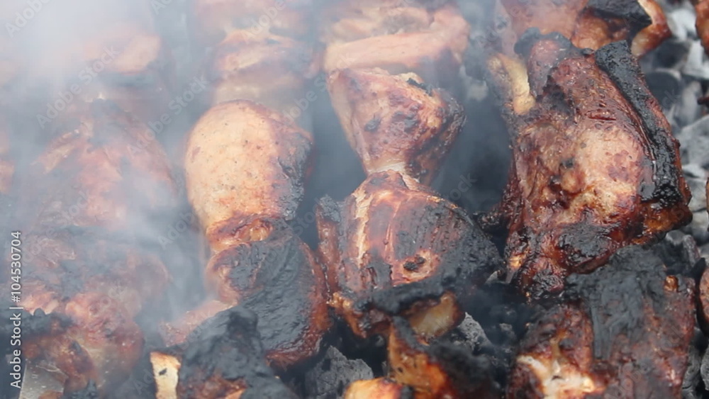 Fatty pork on a skewer roasted on charcoal and around smokes, barbecue Fatty pork on a skewer roasted on charcoal and around smokes, barbecue