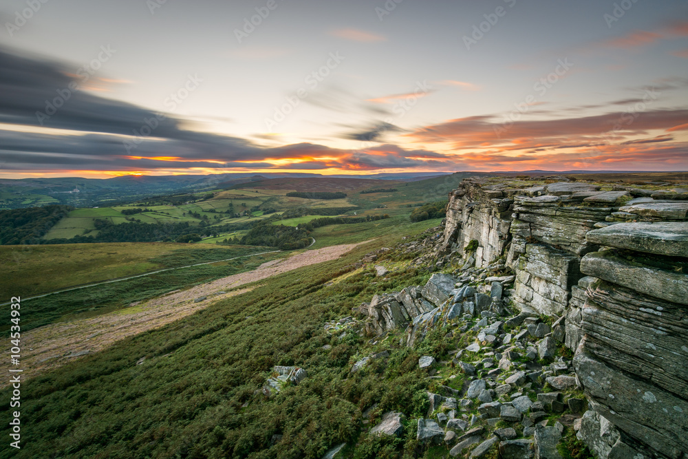 Obraz premium Orange sunset at Stanage Edge in the Peak District, UK.