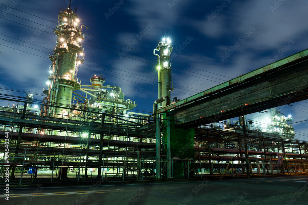 Fototapeta premium Complex network of pipes in factory at night
