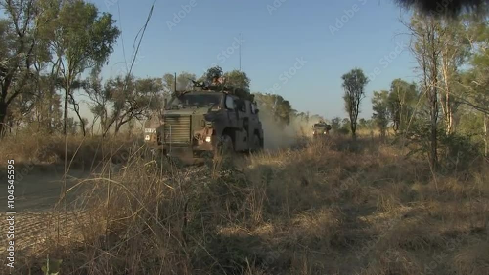 Australian Defense Forces troops move through the outback with armored personnel carriers.