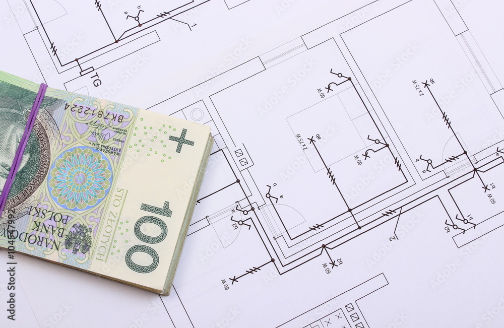 Heap of banknotes on electrical construction drawing of house