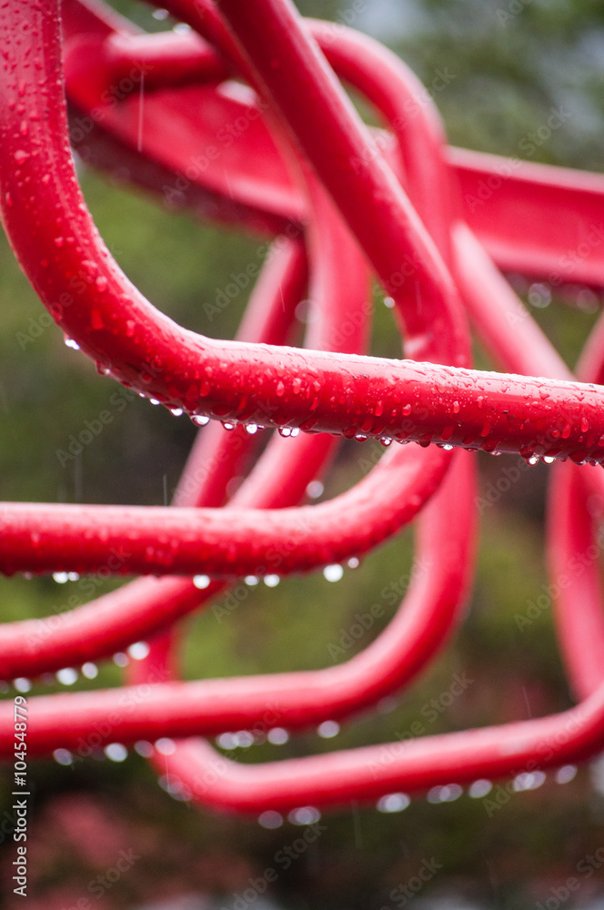 Monkey bars on a school playground at rainy day with drops on the metal, close-up