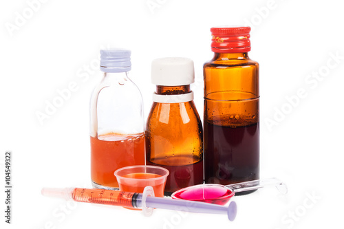 Syrup Medication Bottles and Medicine in Spoons on white backgro