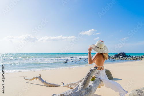 Woman sitting on a tree at the beach