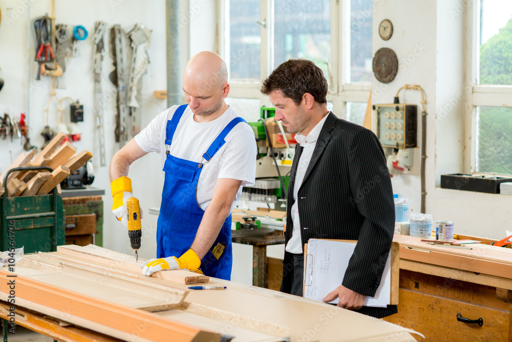 boss and worker in carpenter's workshop boss and worker in carpenter's workshop
