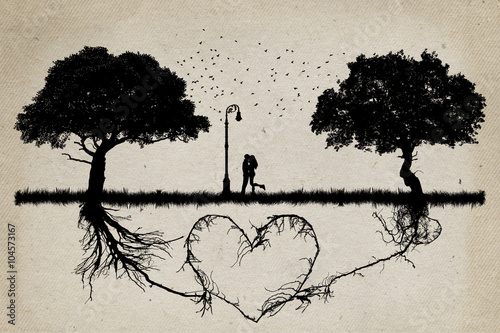 Canvas Print Two trees in front of each other with underground roots growing together in shape of a heart and a couple hugging in the middle