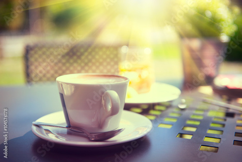 Cup of coffee on the table in sun light
