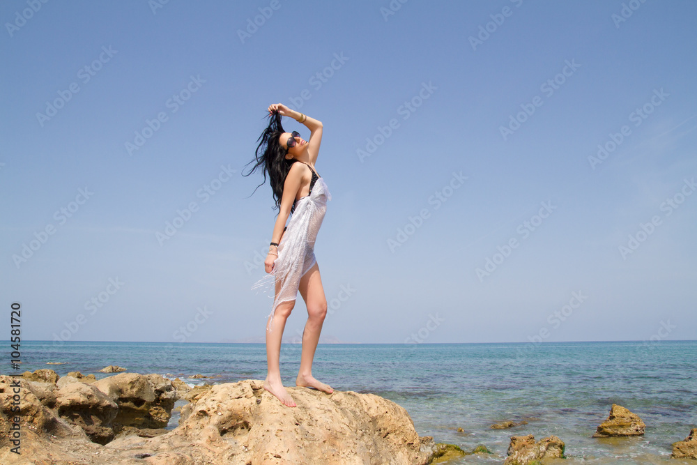 Longhaired brunette in black bikini enjoys summer at the beach. Longhaired brunette in black bikini enjoys summer at the beach.
