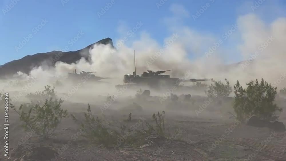 U.S. army tanks fire in the desert.
