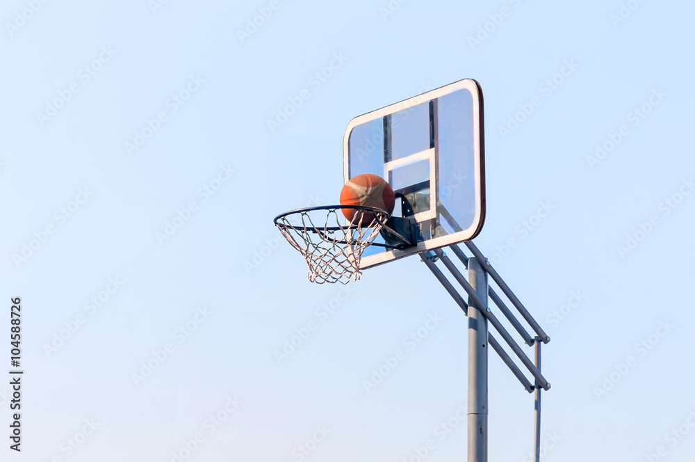 ball into the basketball hoop on the street