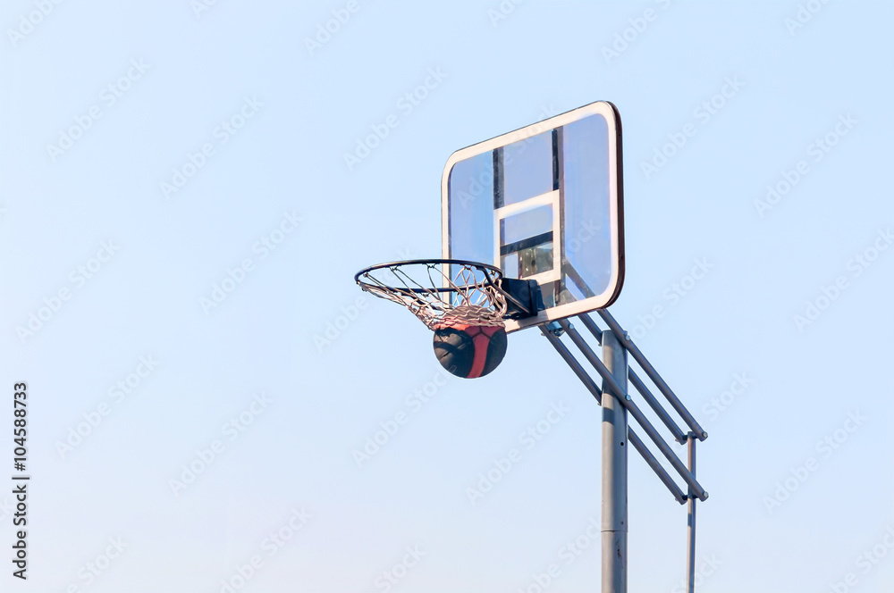 ball into the basketball hoop on the street