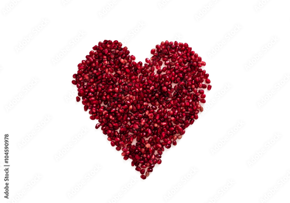Red berries of a pomegranate in a heart shape