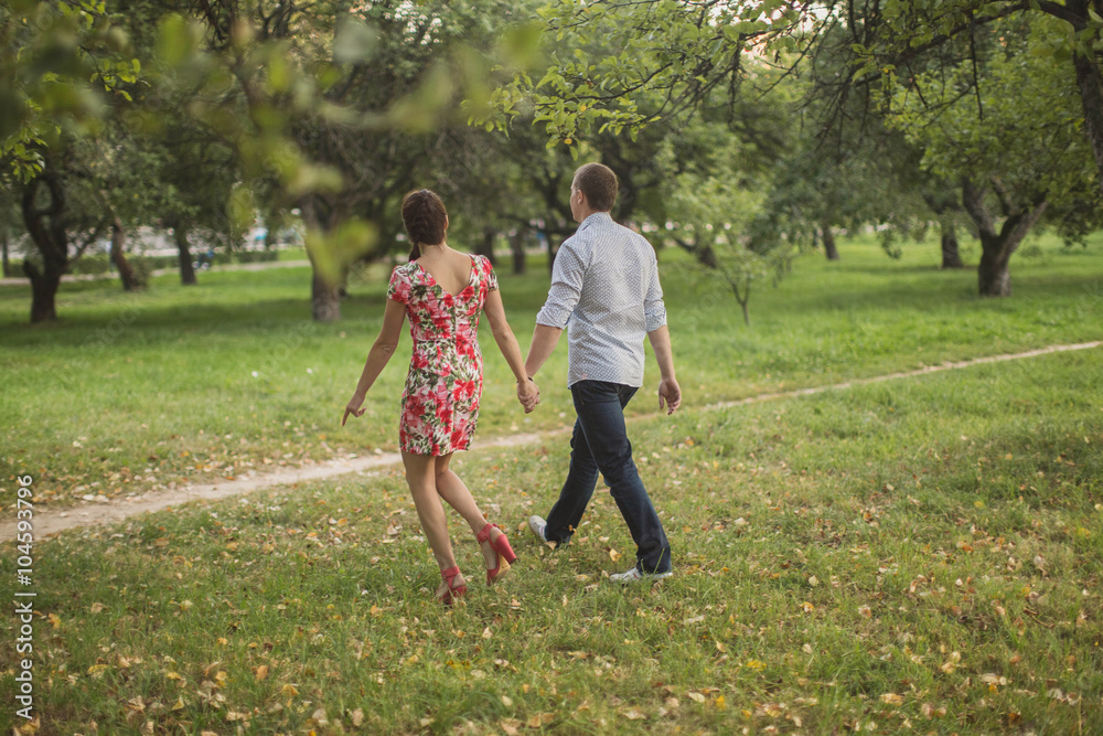 young couple walking in the apple orchard young couple walking in the apple orchard