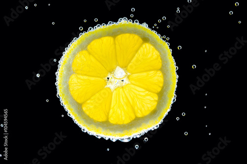 Slice of lemon in the gas water on the black
