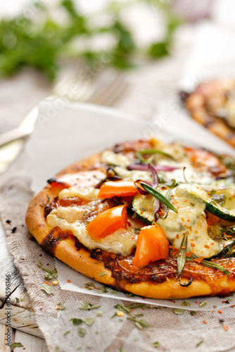 Vegetarian pizza with addition of pepper, zucchini, onion and herbs