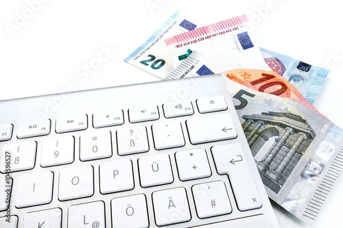 Tastatur und Eurogeldscheine vor weißem Hintergrund