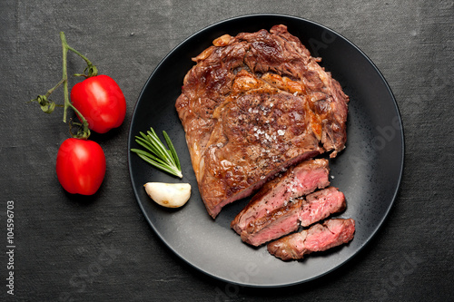 Medium rare grilled Steak Ribeye on dark background. Top view
