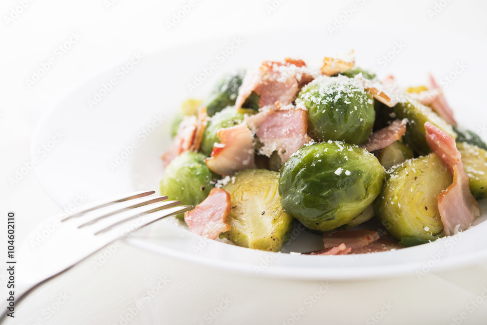 Brussels sprouts with bacon and parmesan on white background close up. Brussels sprouts with bacon and parmesan on white background close up.