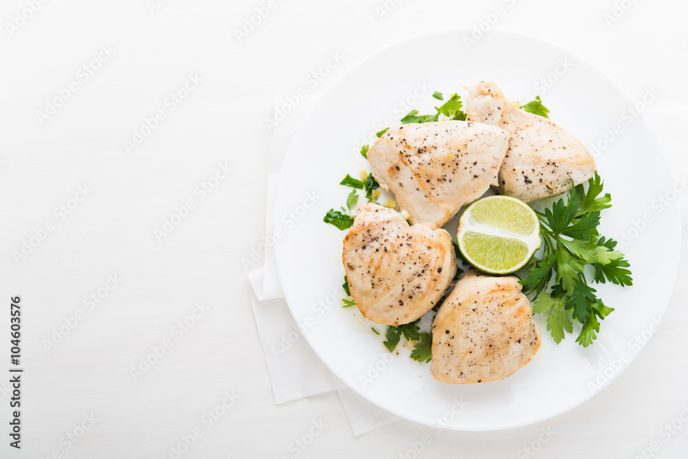 Chicken breasts with parsley and citrus on white background top view. Healthy food. Space for text. Chicken breasts with parsley and citrus on white background top view. Healthy food. Space for text.