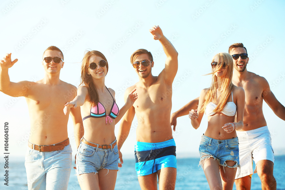 Happy friends running at the beach, outdoors Happy friends running at the beach, outdoors