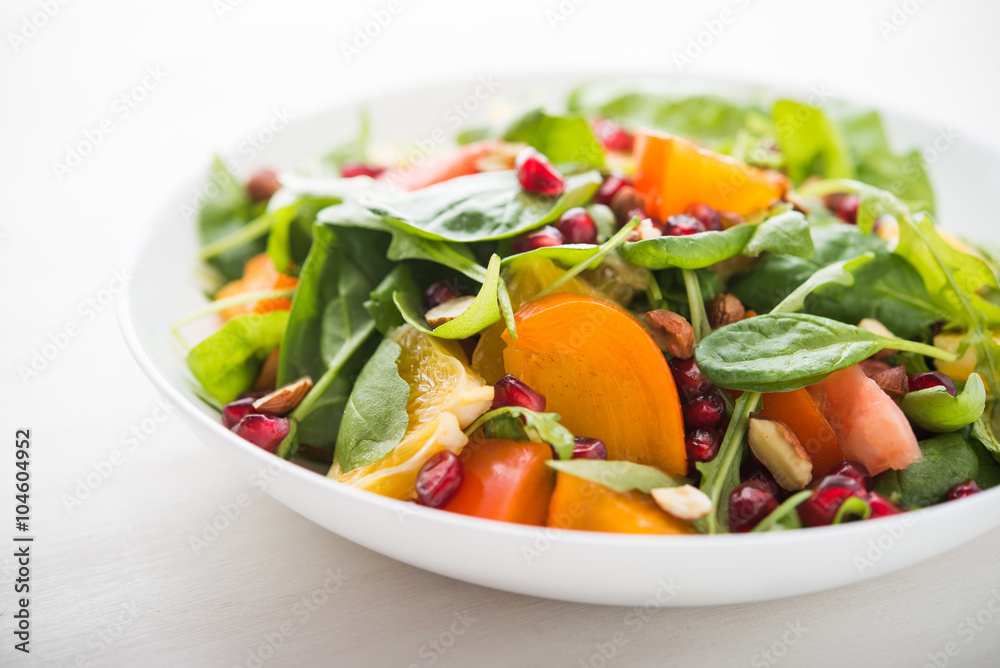 Fresh salad with fruits and greens on white background close up. Healthy food.