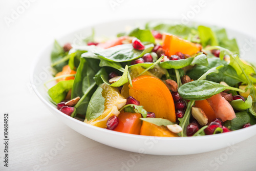 Fresh salad with fruits and greens on white background close up. Healthy food.