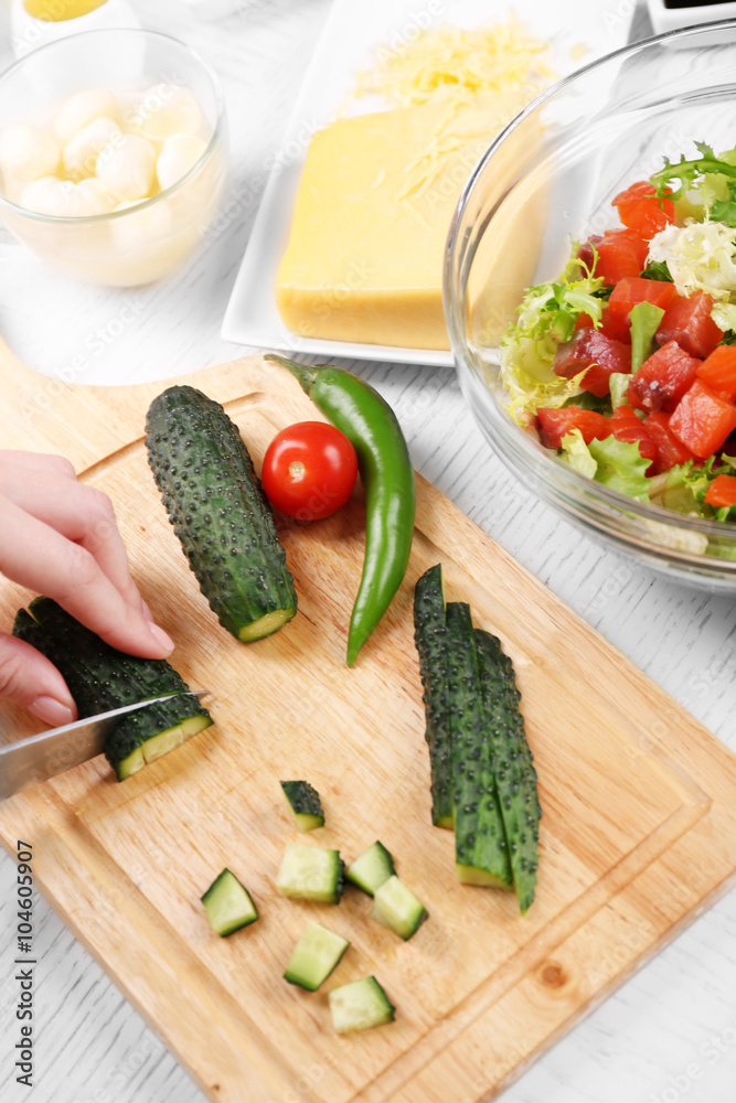 Female hands cutting vegetables for salad, at kitchen Female hands cutting vegetables for salad, at kitchen