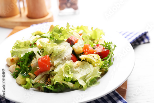 Tasty salmon salad on wooden table background