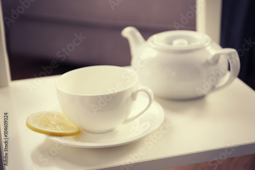 Tea cup and kettle on the table, closeup