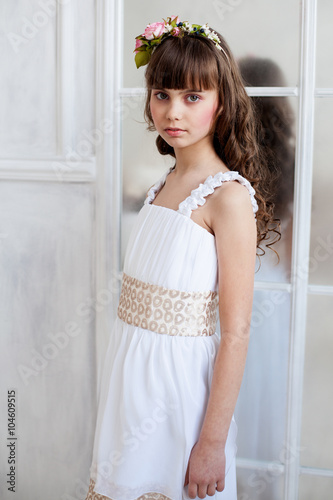 girl in white background standing near the mirror