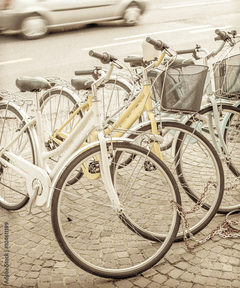 Bikes parked on the pavement.  Vintage effect.