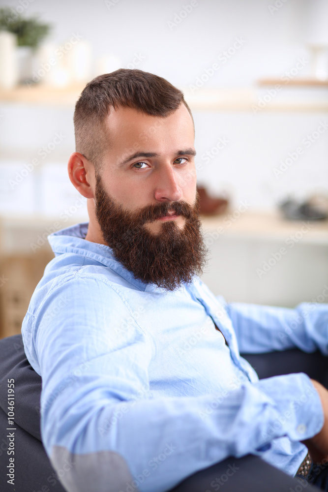 Obraz premium Young businessman sitting on chair in office