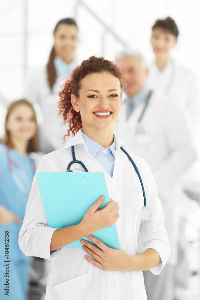 Portrait of doctor in front of colleagues indoors