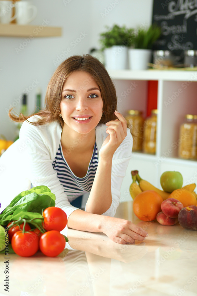 Young woman sitting near desk in the kitchen Young woman sitting near desk in the kitchen