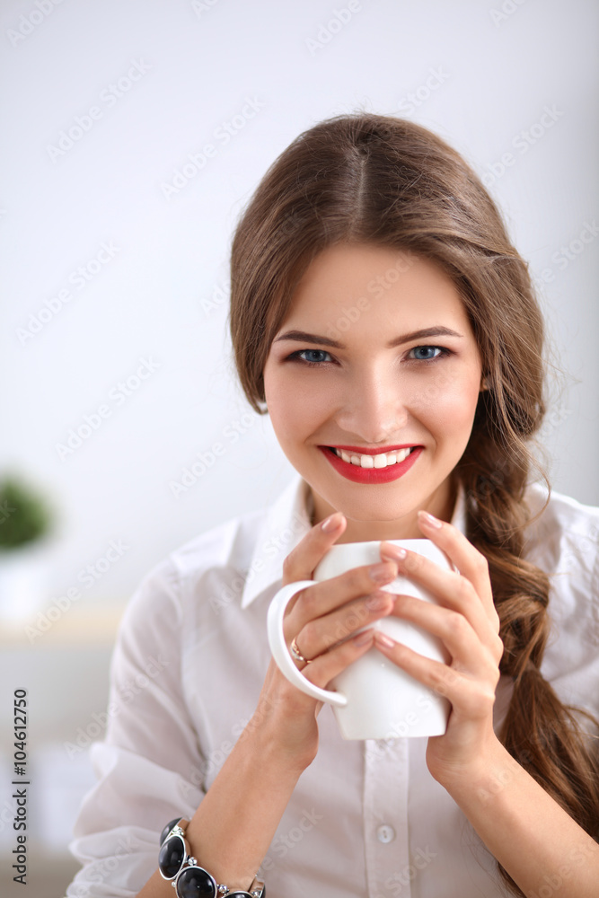Attractive businesswoman sitting on desk in the office Attractive businesswoman sitting on desk in the office