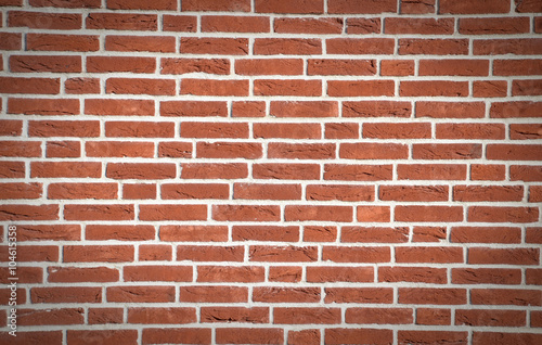 Wall made from red bricks as an background, dark vignette