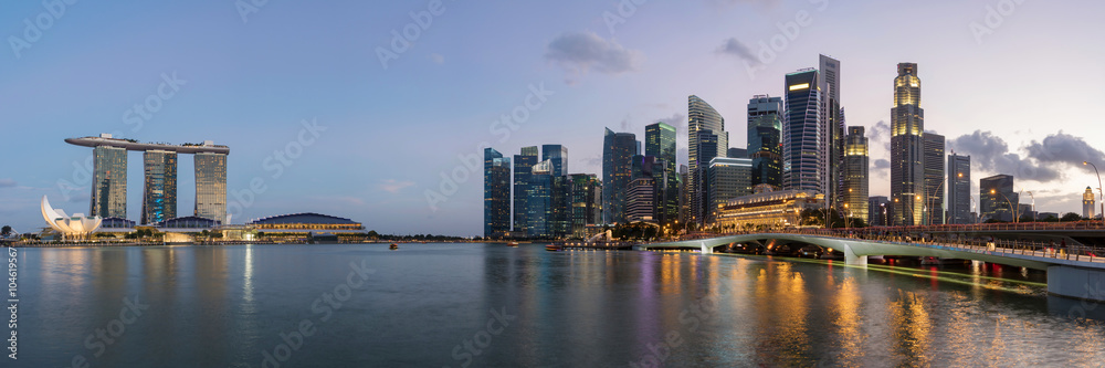 Fototapeta premium Colorful Singapore business district skyline after sun set at Marina Bay. Panoramic image.