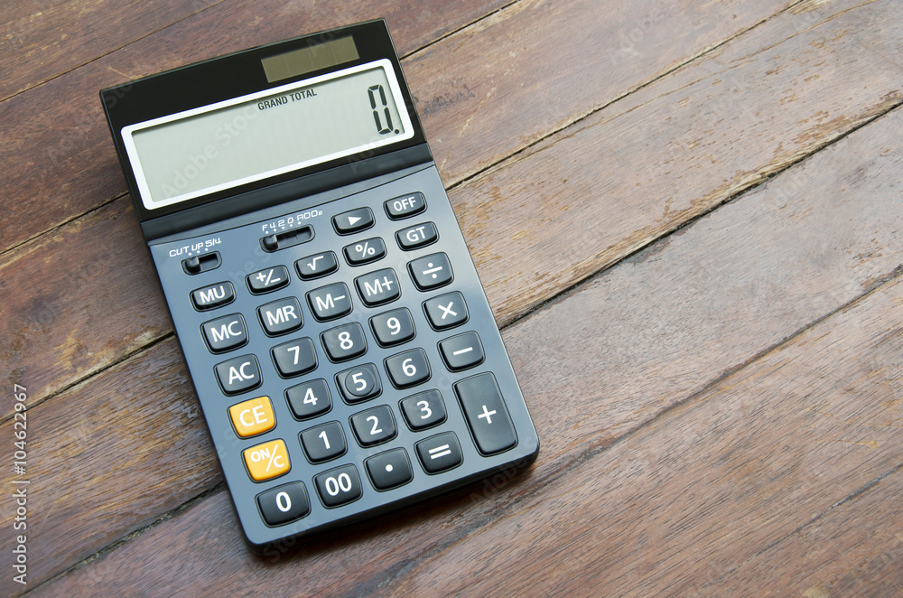 Press the button on the calculator with a wooden floor in the background. Press the button on the calculator with a wooden floor in the background.