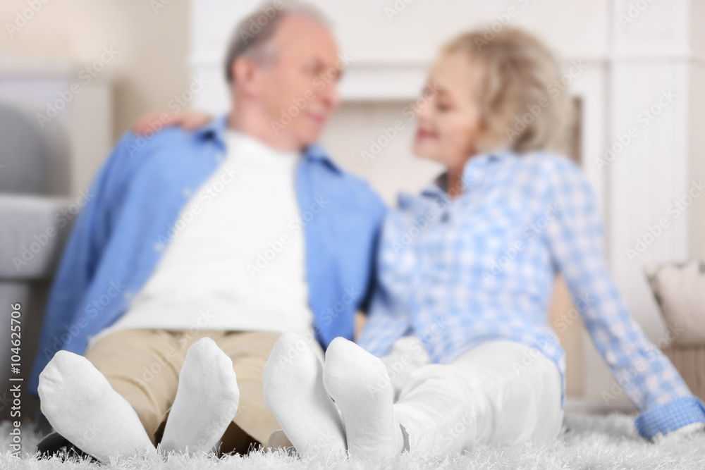 Obraz premium Mature couple sitting together on a floor at home