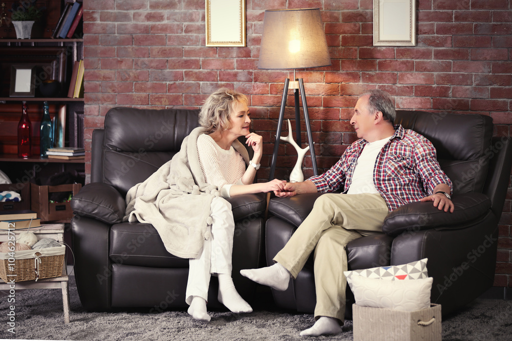 Obraz premium Happy mature couple sitting close at home