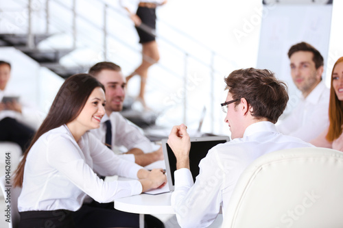 Young businessman with glasses sitting and discussing at the office meeting