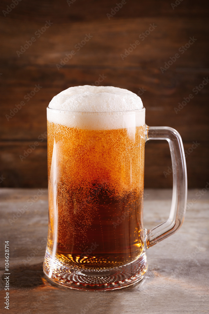 Glass mug of light beer on wooden table, close up Glass mug of light beer on wooden table, close up