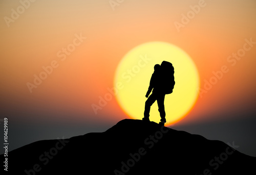 Silhouette of a rock climber on the peak. Sport and active life concept..