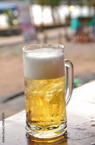 A glass of beer on the table background on a blurred background
