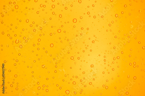 abstract yellow background with raindrops on glass