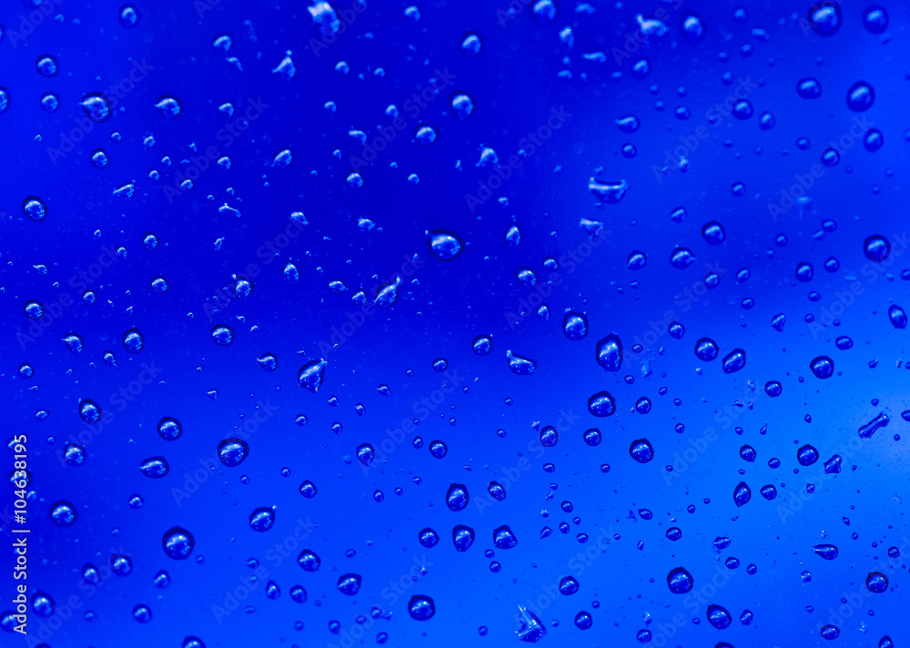 abstract blue background with raindrops on glass