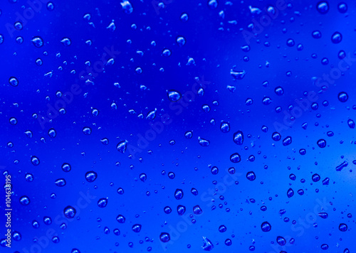 abstract blue background with raindrops on glass