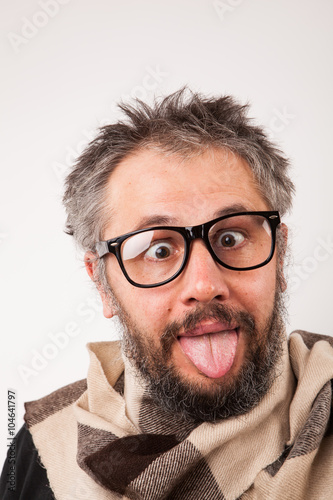Crazy looking old man with grey beard with nerd big glasses show tongue rolling eyes