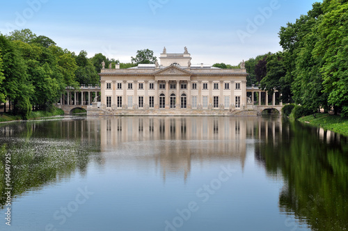 Palace in Lazienki Park in Warsaw reflected in the water and surrounded by trees. Poland.
